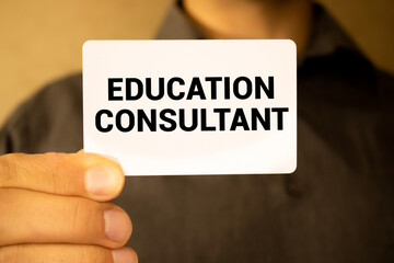 man holding a card that says Education Consultant