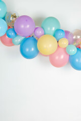 Fototapeta na wymiar A close up image of a soft pastel balloon garland against a white background