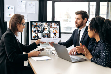 Business multiracial colleagues, discussing new project, generating new ideas, communicating via video conference with their business partners from different countries. Group cooperation by video call