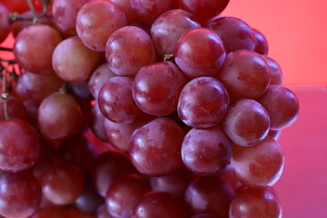 A bunch of red grapes in close-up with mirror effect