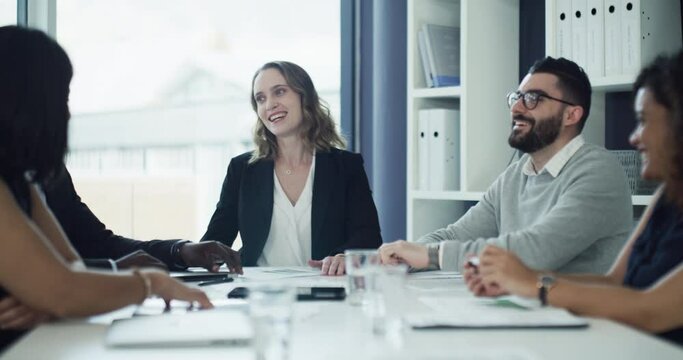 Group of businesspeople laughing and smiling together after planning an innovation project in a collaboration meeting in a modern boardroom office. Team in funny a discussion about a strategy idea