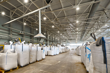 Huge plastic bags with product on pallets at recycling plant
