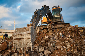 Fototapeta premium Bucket of excavator full of dismantled building leftovers