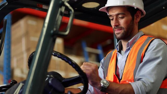 Warehouse staff driving forklift operator moving boxes in industrial container warehouse factory. Man worker woking with forklift.