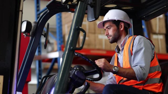 Warehouse staff driving forklift operator moving boxes in industrial container warehouse factory. Man worker woking with forklift.