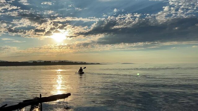 adult woman on a sports holiday she paddles while sitting on a kayak is kayaking for the first time leisure for adults travel agency beautiful weather pacific ocean Parksville beach Surfside RV resort