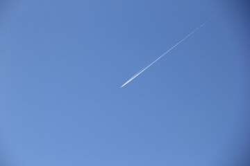 飛行機雲が描かれつつある青空