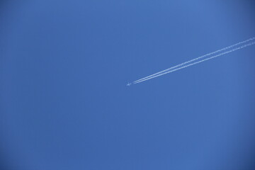飛行機雲が描かれつつある青空