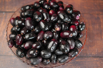 top view of black plum on a plate .
