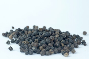close up shots of black peppercorns (Black peppers) isolated against a white background