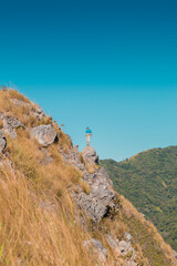 man contemplating a landscape of the green mountains
