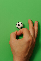 male hand finger football with a miniature toy soccer ball