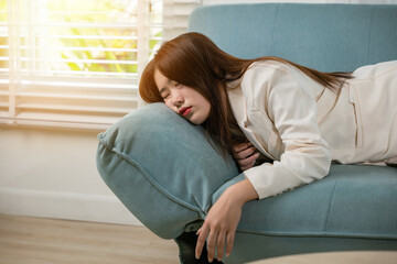 Tired woman sleeping closed eyes on sofa in living room at home after overworked working, Asian female resting falling asleep lying on couch, Close up face