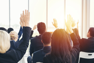 Business people raise hand to the air to speaker at Business Conference. Business people meeting at business conference room