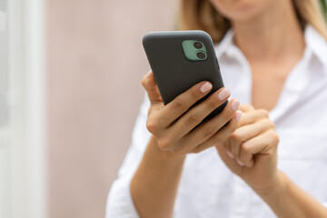 female hands hold a modern mobile phone on the street..education, modern app, shopping order, work online