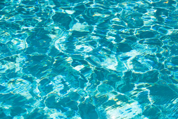 Fototapeta na wymiar Background of blue water in swimming pool with sun reflection, ripple water wave in pool. Clear water background.