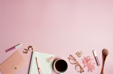 Women working space with notebook, coffee, glasses and flower over the pink background. 