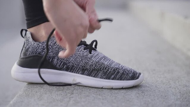 Girl tying up shoelace 