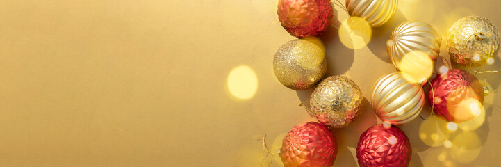 Fototapeta na wymiar beautiful shiny gold and red Christmas baubles on a metallic golden background banner