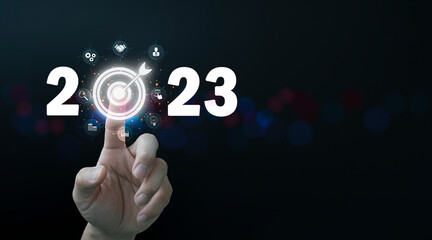 Finger pressing blue start 2023 button on virtual interface on gray background with copy space for text. Concept of new year. Businessman pressing 2023 start up business.