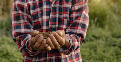 Farmer holding soil in hands close-up..