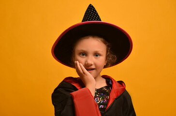 Portrait of cute little wizard girl wearing Halloween costume on a yellow background.

A surprised...