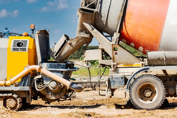 Concrete mixer truck delivers concrete to the pump for pouring piles. Concrete pump at the construction site. Close-up of concrete delivery.