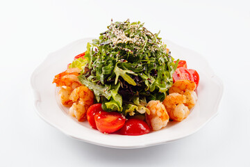 Healthy arugula salad bowl with shrimp, tomato, and sesame seeds