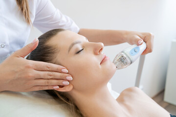 Handle radio frequency apparatus on chin woman's face during skin rejuvenation beauty lifting...