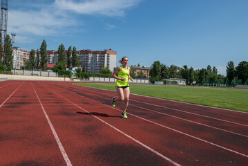 Fototapeta premium woman runs in the stadium.