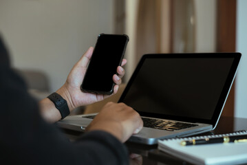 Screen computer mockup for advertising text, Male hand using smartphone and laptop texting contact business search information on desk in marketing office and design.