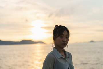 夕暮れの海を散策する女性