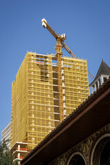 Fototapeta premium Albania, May 12, 2022 - Construction crane on top of unfinished building.