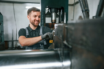 Professional engineer operating machine. Man in uniform is in workstation developing details of agriculture technique