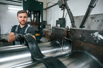 Fototapeta premium Professional engineer operating machine. Man in uniform is in workstation developing details of agriculture technique