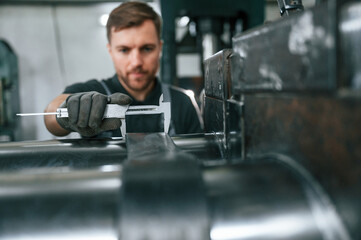 Using measure tool. Man in uniform is in workstation developing details of agriculture technique