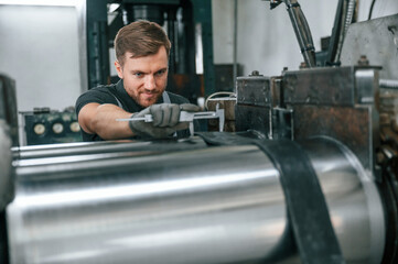 Using measure tool. Man in uniform is in workstation developing details of agriculture technique