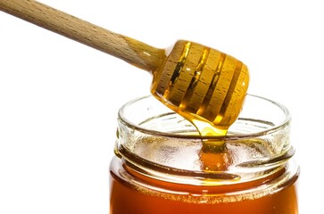 Honey in a glass jar with wooden honey dipper