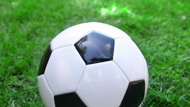 A camera rotating around a football soccer ball on a green grass field. Classic Black White Outdoor Football Ball Standard Adult, Soccer Ball Training Ball