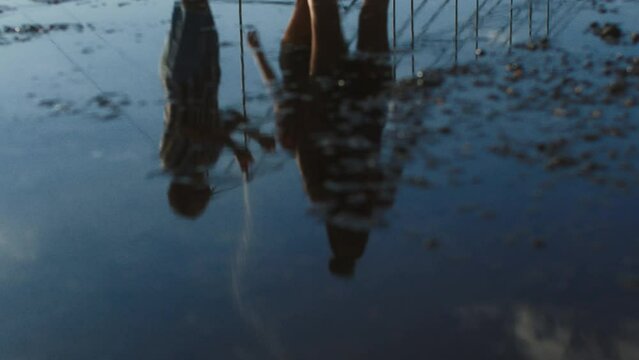 young people having fun viewed by puddle reflection