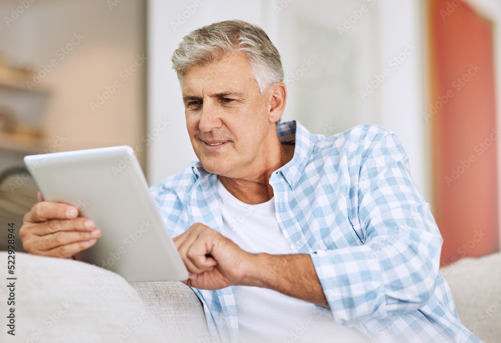 Poster mature and senior man browsing on tablet, searching the internet and scrolling on social media while