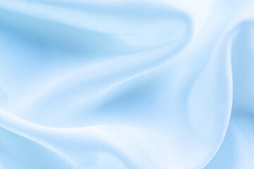 blue silk texture. background of blue fabric lying folds on the table