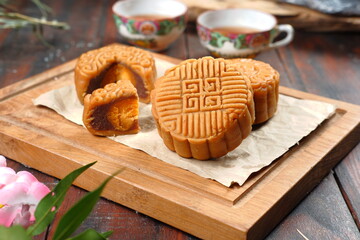 Mooncake, Moon cake (yue bing }-Chinese traditional pastry with tea cups on dark background,...