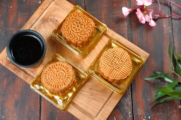 Mooncake, Moon cake (yue bing }-Chinese traditional pastry with tea cups on dark background,...
