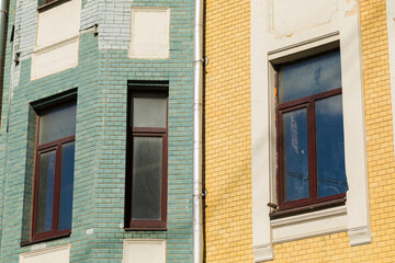 Fototapeta na wymiar Windows of 19th century building. Wall of the color tiles.