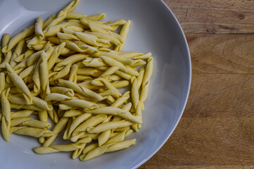 raw strozzapreti, specialties from northern Italy, fresh twisted pasta that cooks very quickly and is suitable for chunky sauces