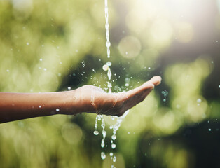 Hygiene, washing and saving water with hands against a green nature background. Closeup of one...