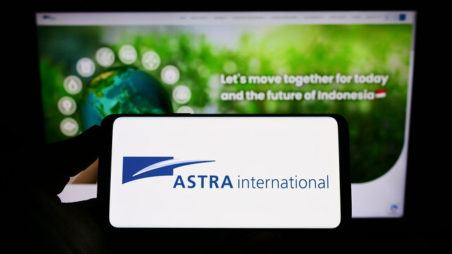 Stuttgart, Germany - 07-31-2022: Person holding smartphone with logo of Indonesian company PT Astra International Tbk on screen in front of website. Focus on phone display.