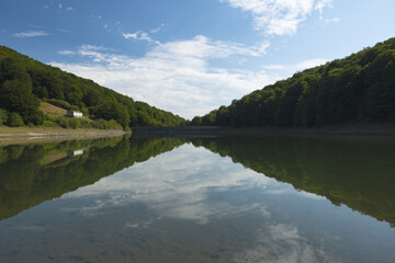 The sky and the beech forest are reflected in the Leurtza reservoir, Navarre.