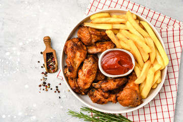 Spicy chicken wings with potatoes fries and ketchup